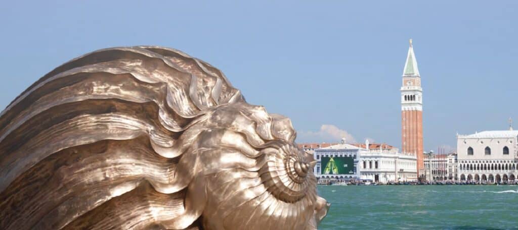 Bronze sculptural head in foreground with Venice's St.